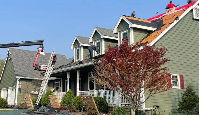 roof repair service with asphalt shingles by workers