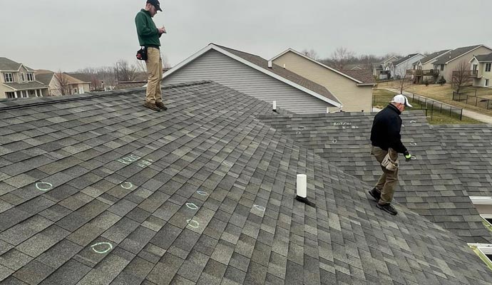 Professional worker inspecting roof damage